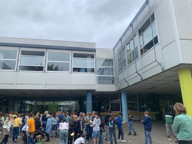 Kinder suchen auf dem Schulhof nach Karten