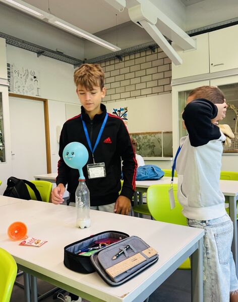 Schüler blasen Luftballons mithilfe einer chemischen Reaktion mit CO2 auf.